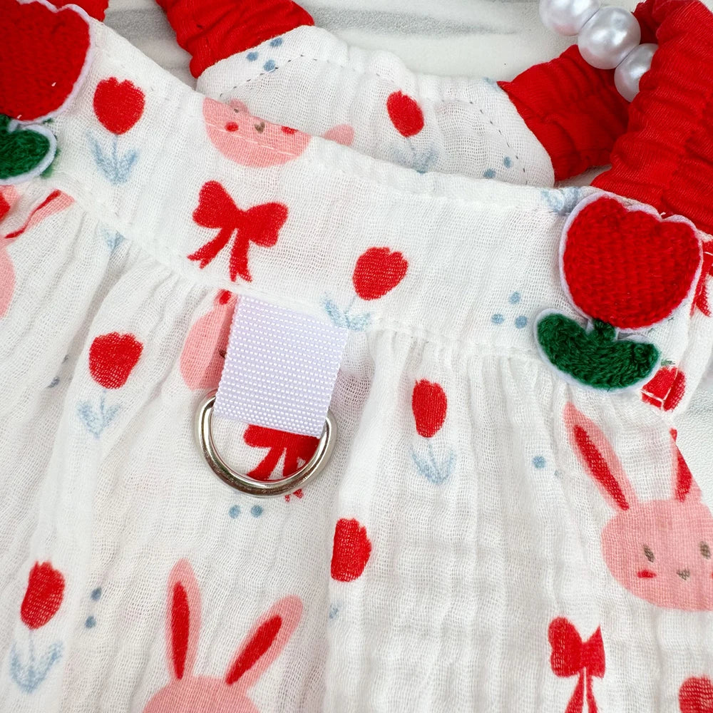 Detalle del vestido para perro en rojo o verde con estampado de conejitos y fresas.