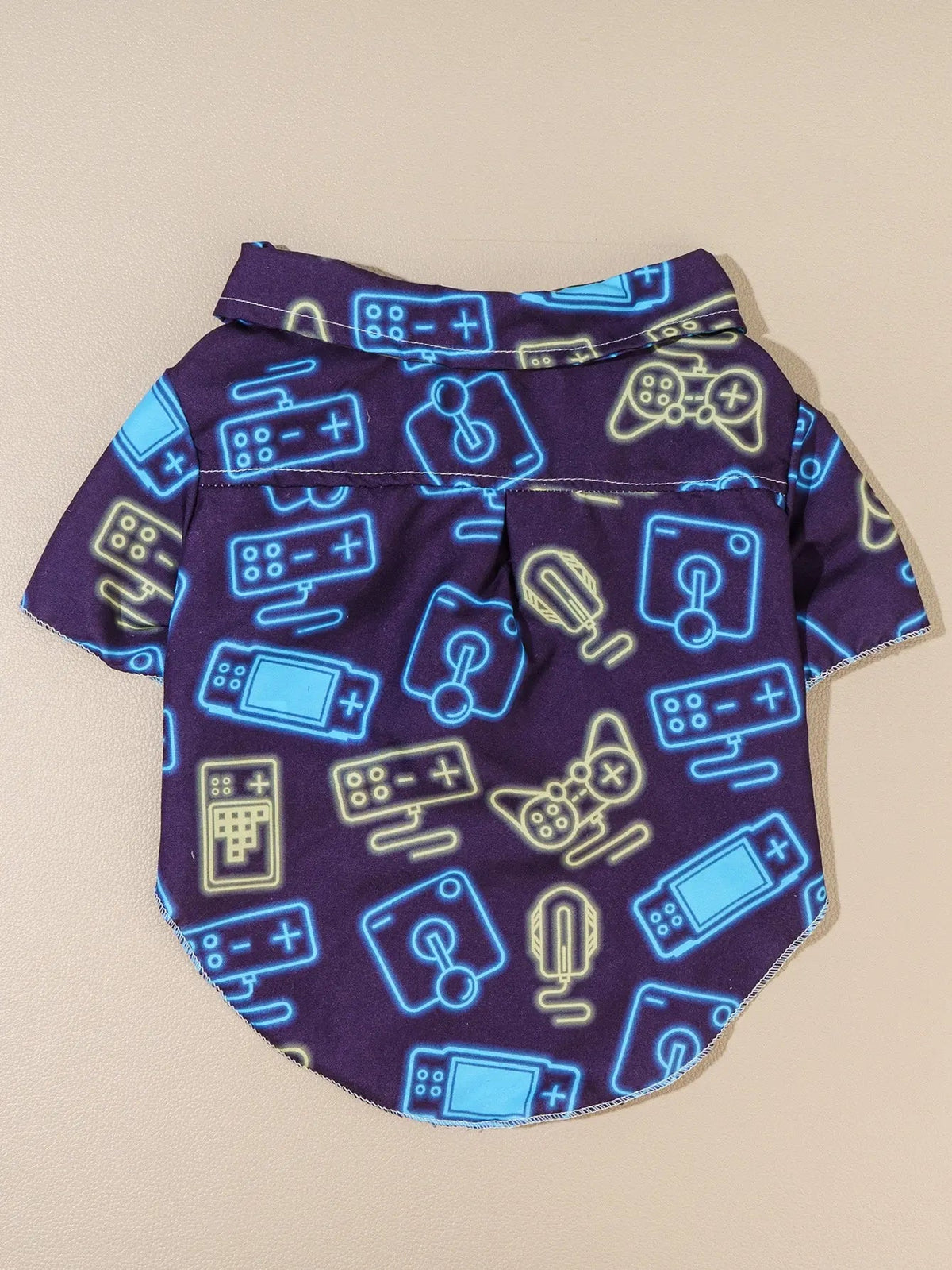 Camisa gamer para perro con estampado de controles en tonalidades neón sobre fondo morado.