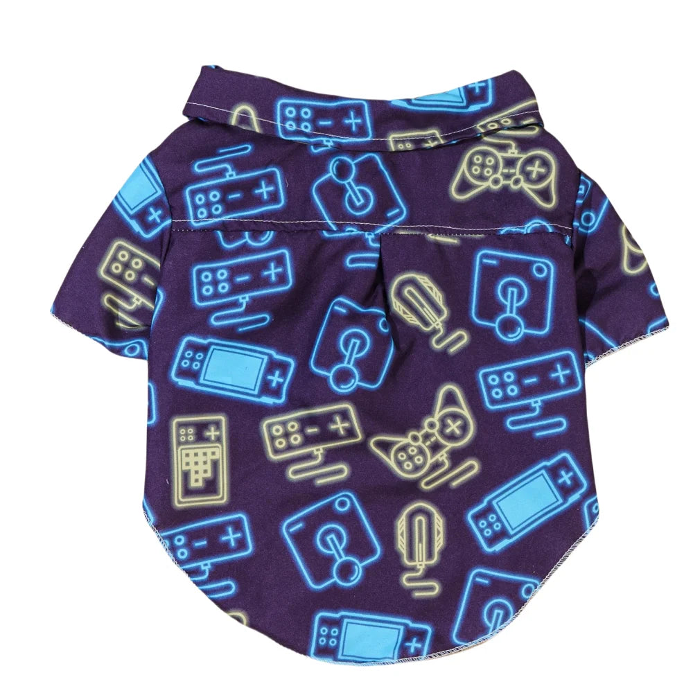 Camisa gamer para perro con estampado de controles en tonos neón sobre fondo morado.
