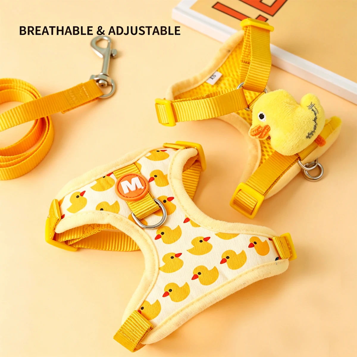 Conjunto de arnés y correa para perro pequeño en color amarillo con diseño de patitos, ajustable y transpirable.