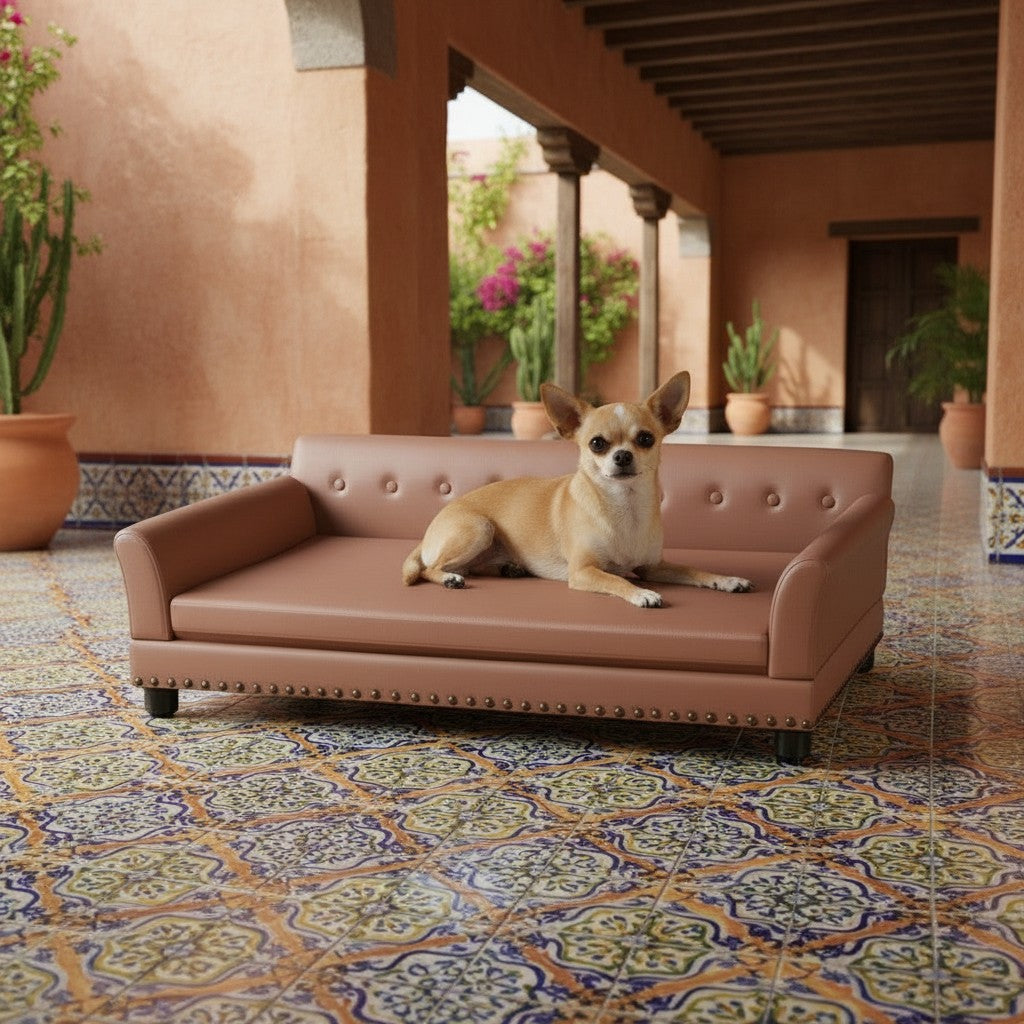 Canapé pour chien MITZON en cuir synthétique marron avec finition capitonnée, installé sur une terrasse ensoleillée.