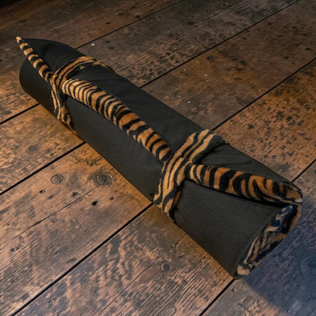 Colchoneta de viaje enrollada MITZON Tiger Edition con estampado de tigre y base negra sobre suelo de madera